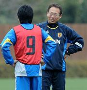 練習中、同じポーズで話し合うＭＦ香川（左）と岡田監督