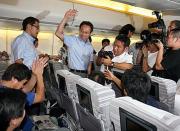 チャーター機のサポーターに勝利報告をした岡田監督は、大声援に手を振る