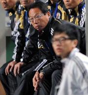 日本対香港　前半、ベンチから身を乗り出して試合を見守る岡田監督