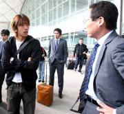 香港空港で岡田監督（右）と話し込む中村俊。中央は岩政