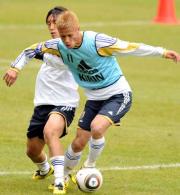 ミニゲームで、中村俊（左）からボールを奪う本田（撮影・栗山尚久）