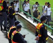 警察官の横を通り、スタジアムに入る日本代表の選手たち